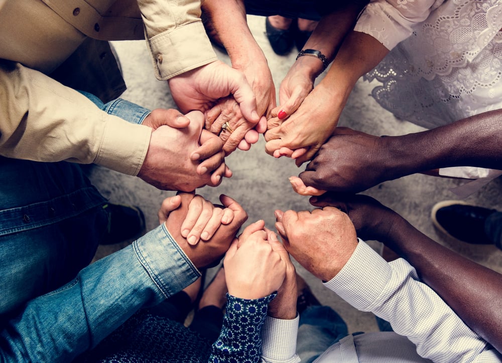 Group of diverse hands holding each other support together aerial view