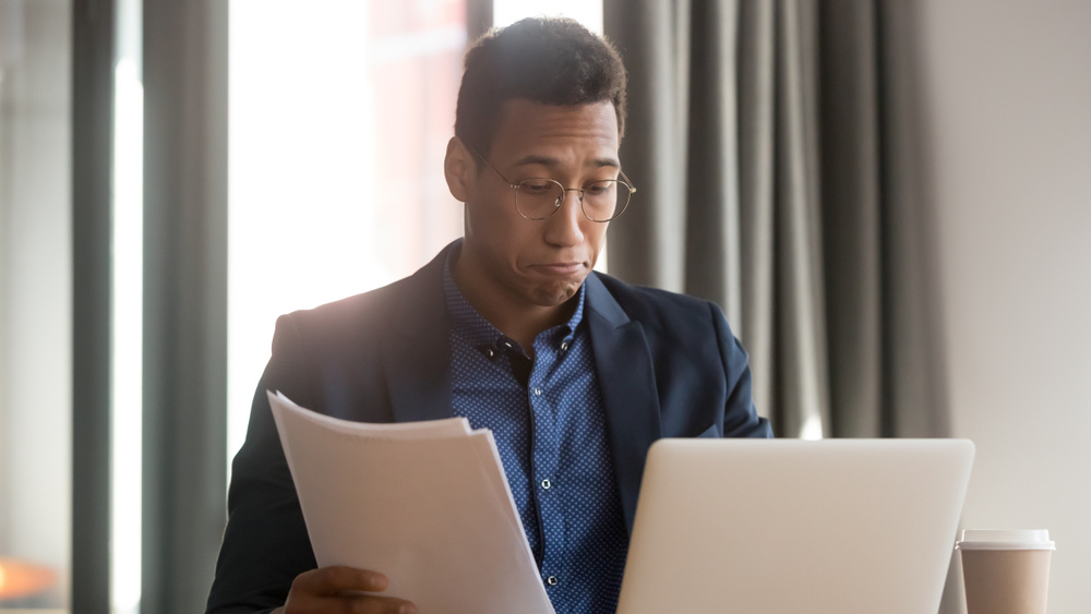 Confused African American man reviewing documents