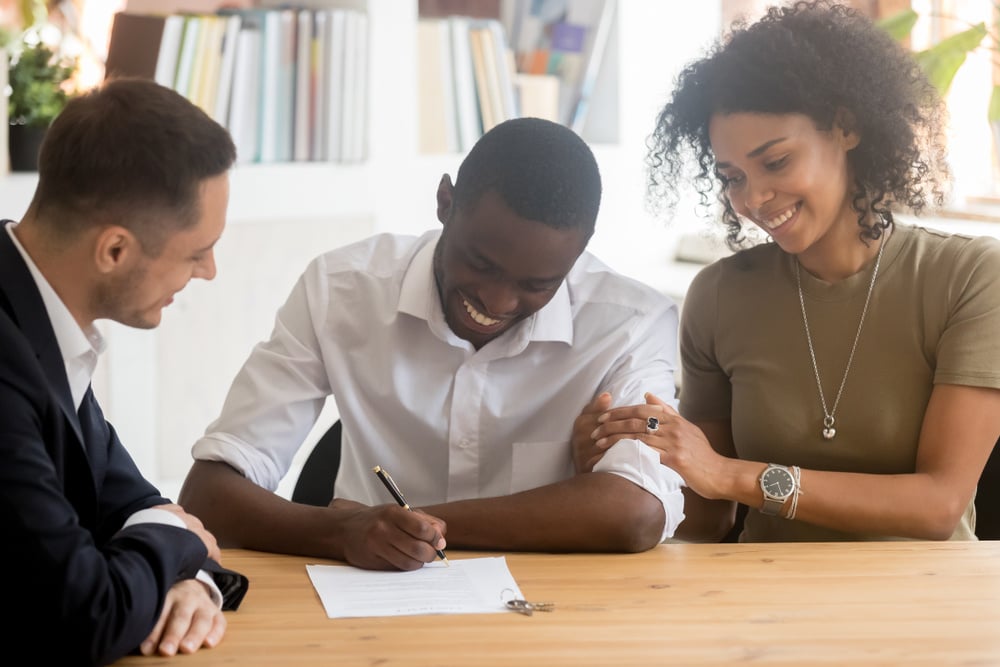 Happy black millennial couple sign contract