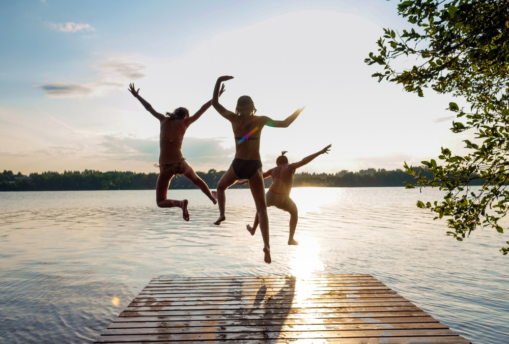 Three kids jumping off dock