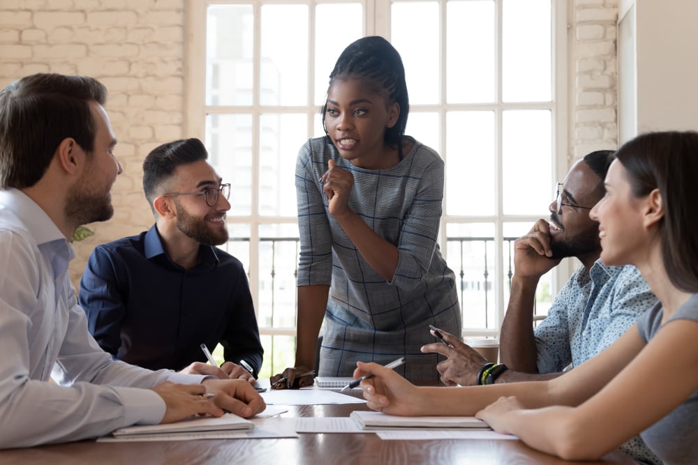 Female leader talking to happy diverse employee group