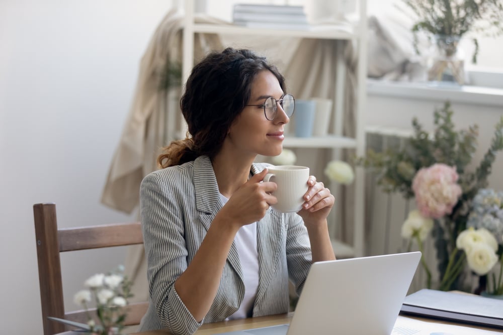 Woman sitting in kitchen holding mug