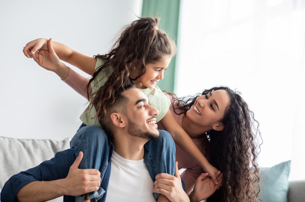 Cheerful family of three having fun together at home