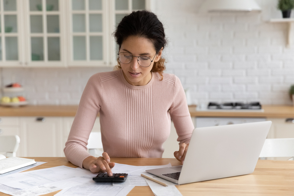 Focused millennial Latina woman calculating finances