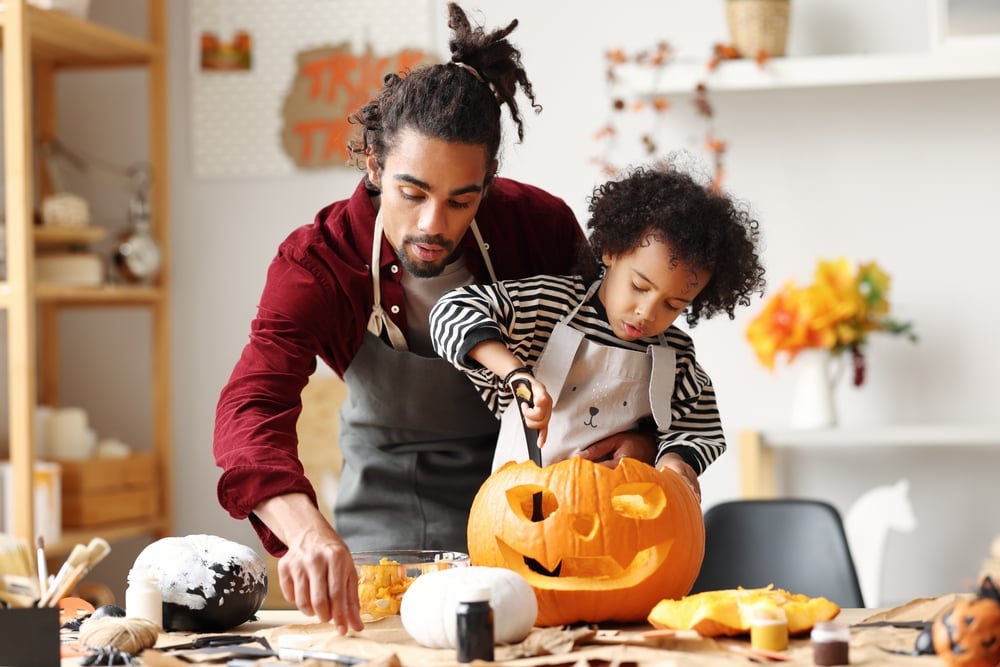 Father and son carving pumpkin