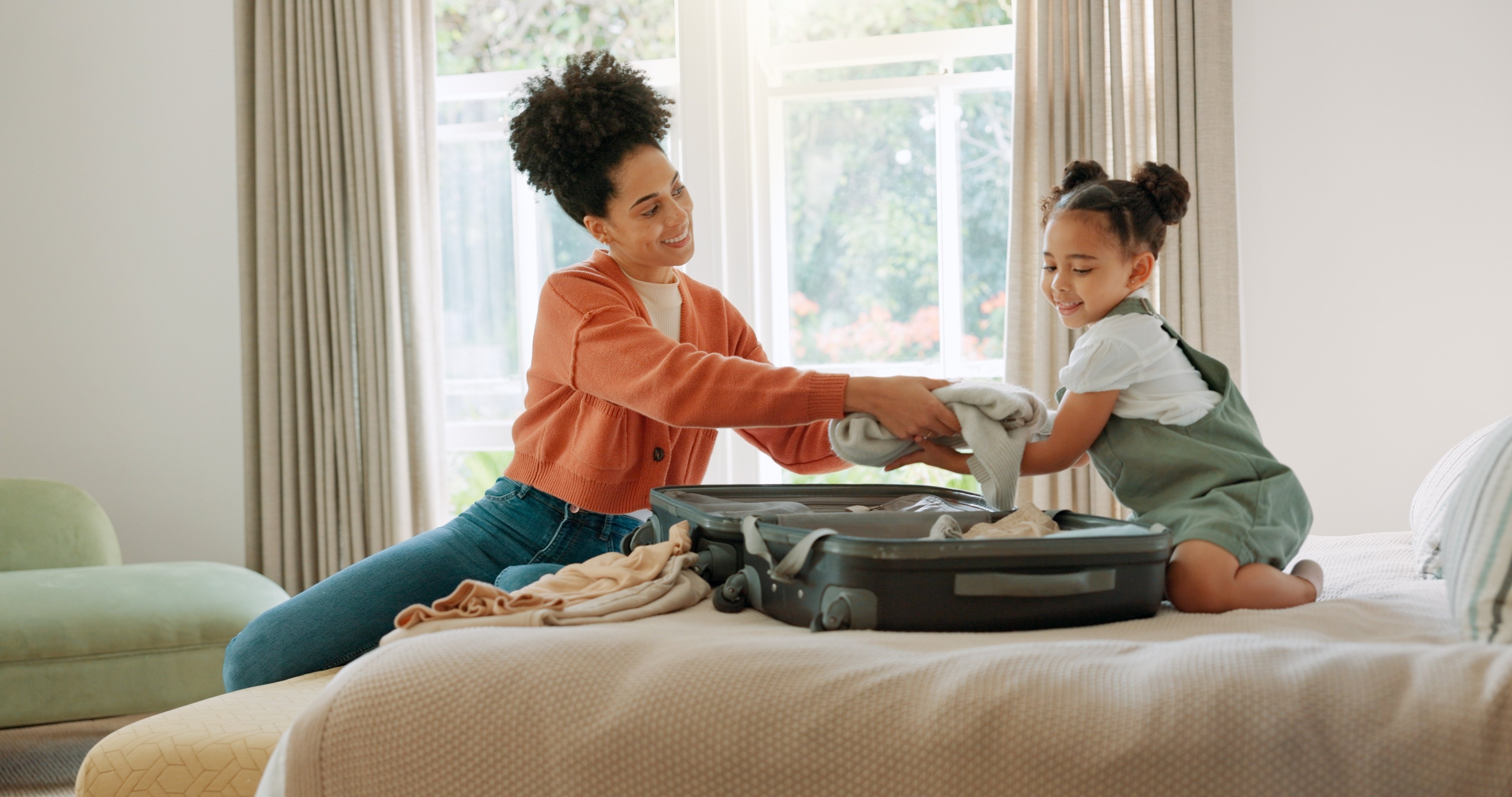 single mother and daughter packing suitcase