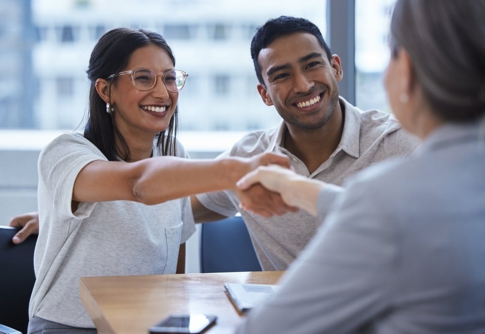 Couple shaking hands with lawyer