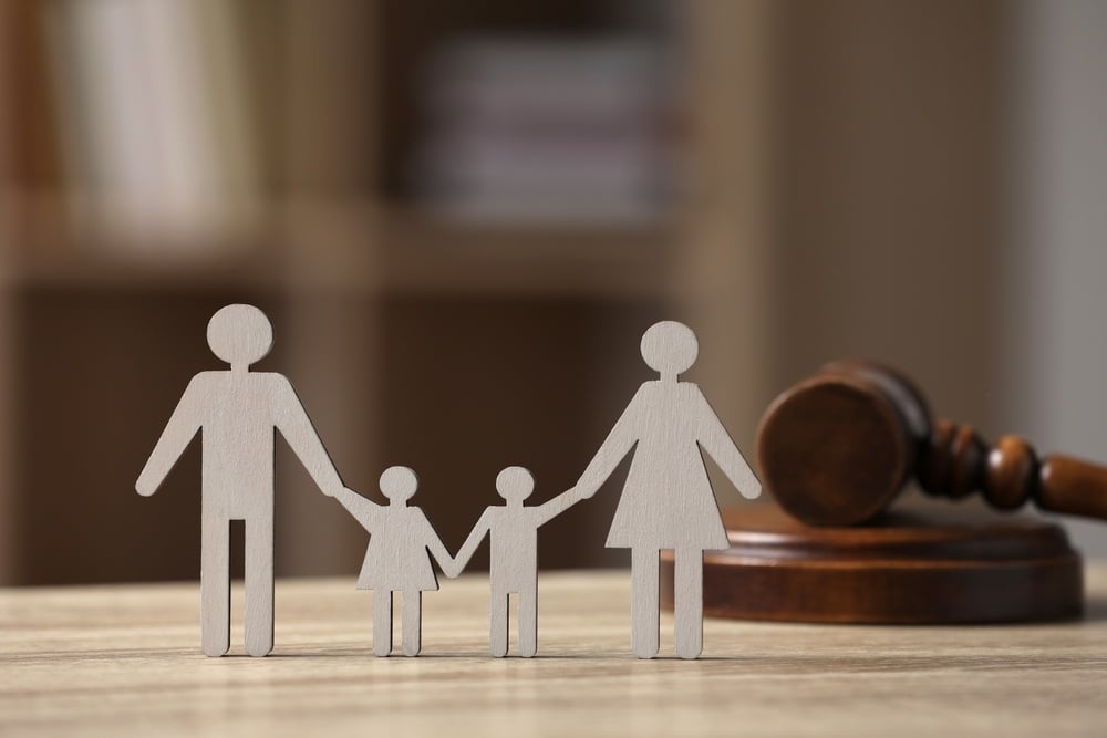 Family law. Figure of parents with children and gavel on wooden table