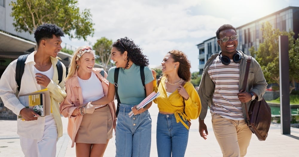 Happy, university and conversation with friends and class diversity on college campus with smile. 