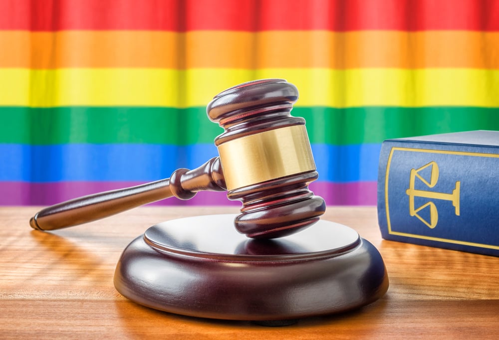 Gavel in front of Pride flag with law book